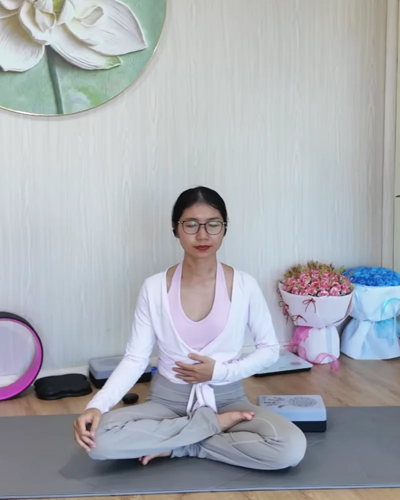 Tâm An ngồi thiền, một tay đặt trên bụng để cảm nhận hơi thở